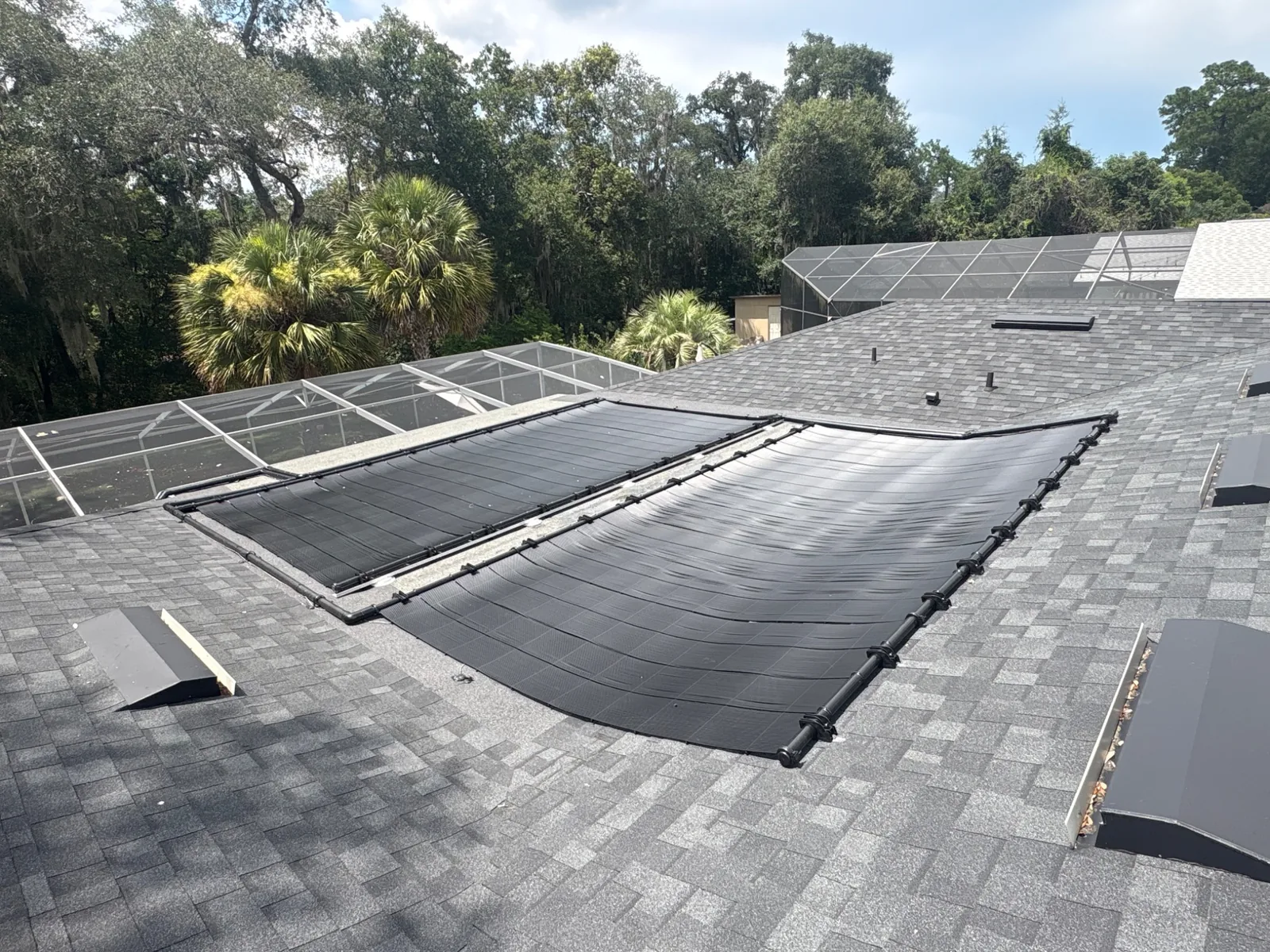 Solar pool heating panels installed on a shingle roof in Central Florida.