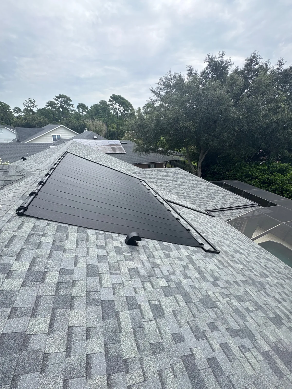 Solar pool heating collectors installed across a residential roof.