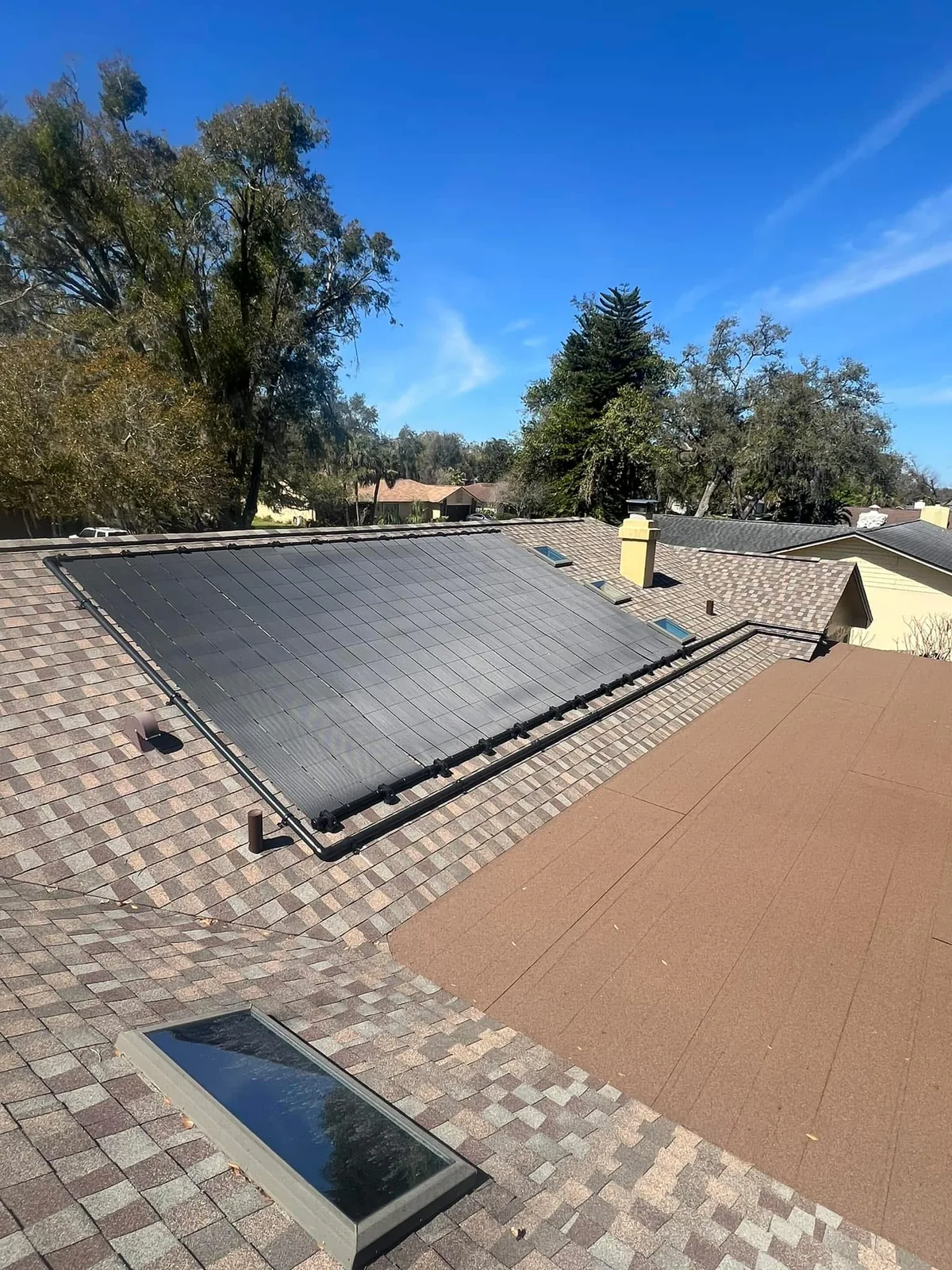 Large solar pool heating collector array installed on a residential roof.