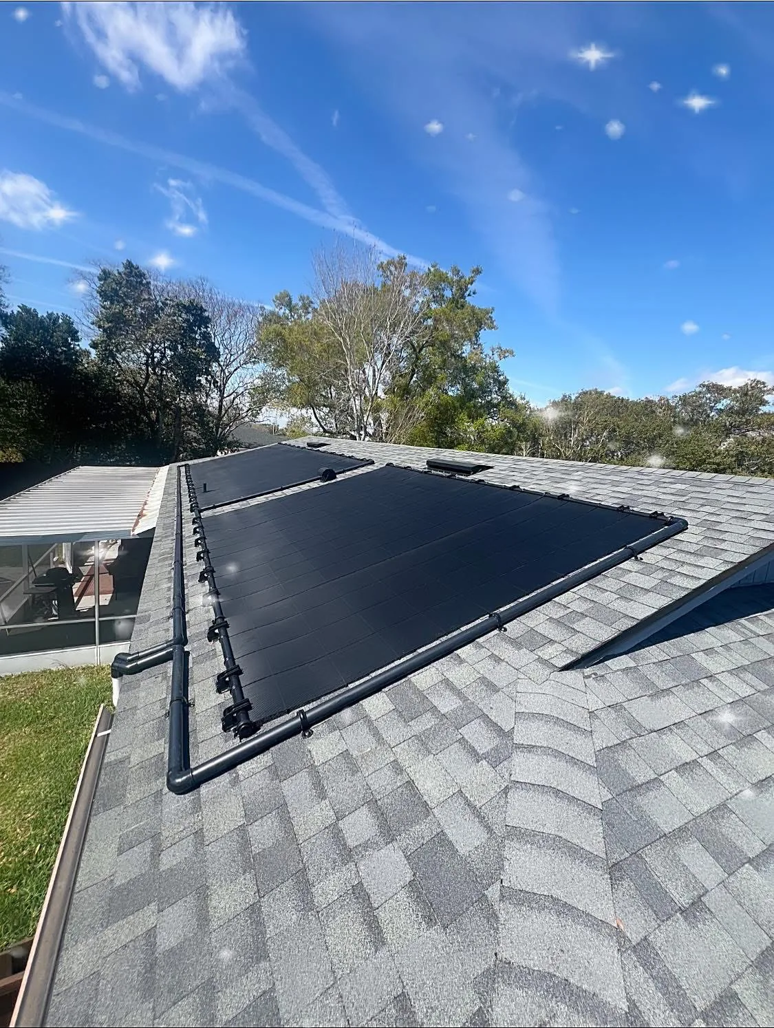 Solar pool heating collectors installed across multiple roof sections.